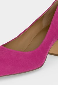 Ροζ παπούτσι από σουέντ με τετράγωνη μύτη, τακούνι block και καφέ εσωτερική επένδυση.