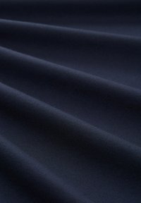 Navyblått tyg med en slät textur, som har mjuka veck och ett enhetligt vävmönster, lämpligt för olika textiltillämpningar.