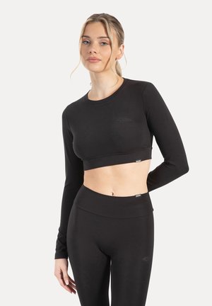 Sort langærmet crop top og matchende højtaljede leggings lavet af strækbart materiale, med et subtilt logodetalje på brystet og taljebåndet.