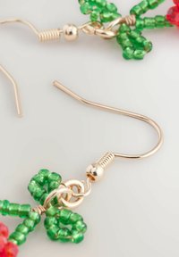 Perlenohrringe mit grünen und roten Designs, vergoldeten Haken, die blumige Formen mit strukturierten Perlen und präzisen metallischen Akzenten zeigen.