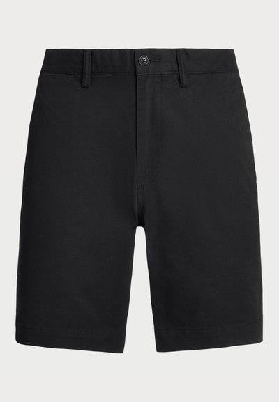 Calções de algodão pretos com frente lisa, fecho de botão e passadores para cinto. Apresenta pernas direitas e uma bainha limpa. Sem padrões ou detalhes visíveis.