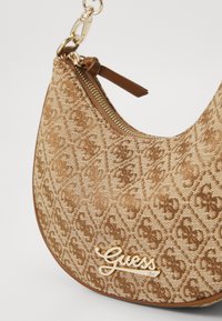 Sac à main marron à motif avec un design en tissu texturé, featuring un logo et des détails zippés en ton doré. Forme incurvée et accents contrastants.