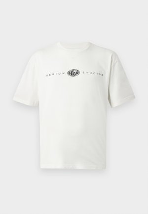 Wit T-shirt met korte mouwen, zwart wereldbollogo en de tekst "DESIGN STUDIOS" over de borst op een effen achtergrond.