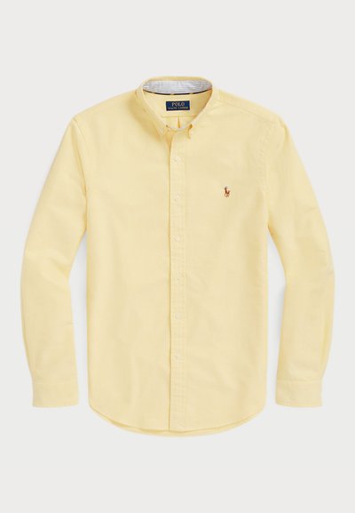 Rumena srajca z gumbi, izdelana iz bombaža, z dolgimi rokavi, ki ima klasičen ovratnik in majhen vezena logotip na prsih.