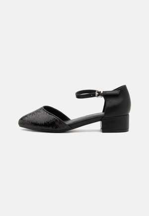 Chaussure noire pour femme à talon bas avec bride à la cheville, bout pointu couvert de sequins noirs et talon fermé sur fond blanc.