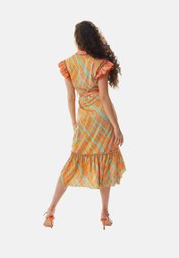 Bright orange dress with multicolored plaid pattern, ruffled sleeves, and a flared hem. Tied waist detail and lightweight fabric.