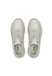 Light gray sneakers with a smooth leather upper, textured mesh accents, and larger rubber soles. Features flat laces and logo on the insole.