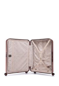Harde koffers in metallic roségoud, met een gestructureerd ribbelontwerp, zachte beige binnenzijde, ritszakken en kruisbanden voor het beveiligen van spullen.