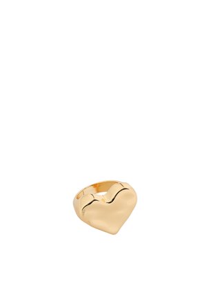 Bague en or avec un dessus en forme de cœur lisse et brillant sur un fond blanc uni.