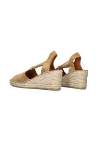 Suede wigwams in lichtbruin, met een geweven juten platform, open zijkanten en een gladde afwerking.