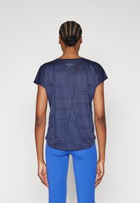 Marinblå kortärmad träningsoberolla med ett geometriskt mönster, rundad nederkant och texten "ONLY PLAY" nära halsringningen.