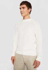 Weißer Strickpullover mit gerippten Bündchen und Saum. Verfügt über eine strukturierte Oberfläche, einen Rundhalsausschnitt und ein schlankes Design.