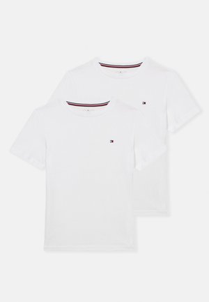 Zwei schlichte weiße Kurzarm-T-Shirts mit Rundhalsausschnitt, kleinem rot-weiß-blauem Logo auf der linken Brust und gestreiftem Kragen-Detail.