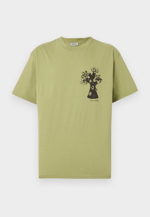 Lysegrøn T-shirt med korte ærmer og et sort abstrakt blommetræsgrafik på venstre brystområde samt lille tekst under designet.