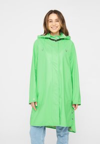 Impermeable verde con capucha, mangas largas, botones a presión y dos bolsillos frontales. Textura suave y diseño holgado.