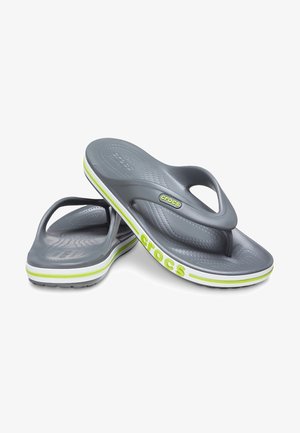 Une paire de tongs Crocs grises avec des rayures vert lime et blanches sur les semelles, des semelles texturées, et des logos Crocs sur les brides et les côtés.