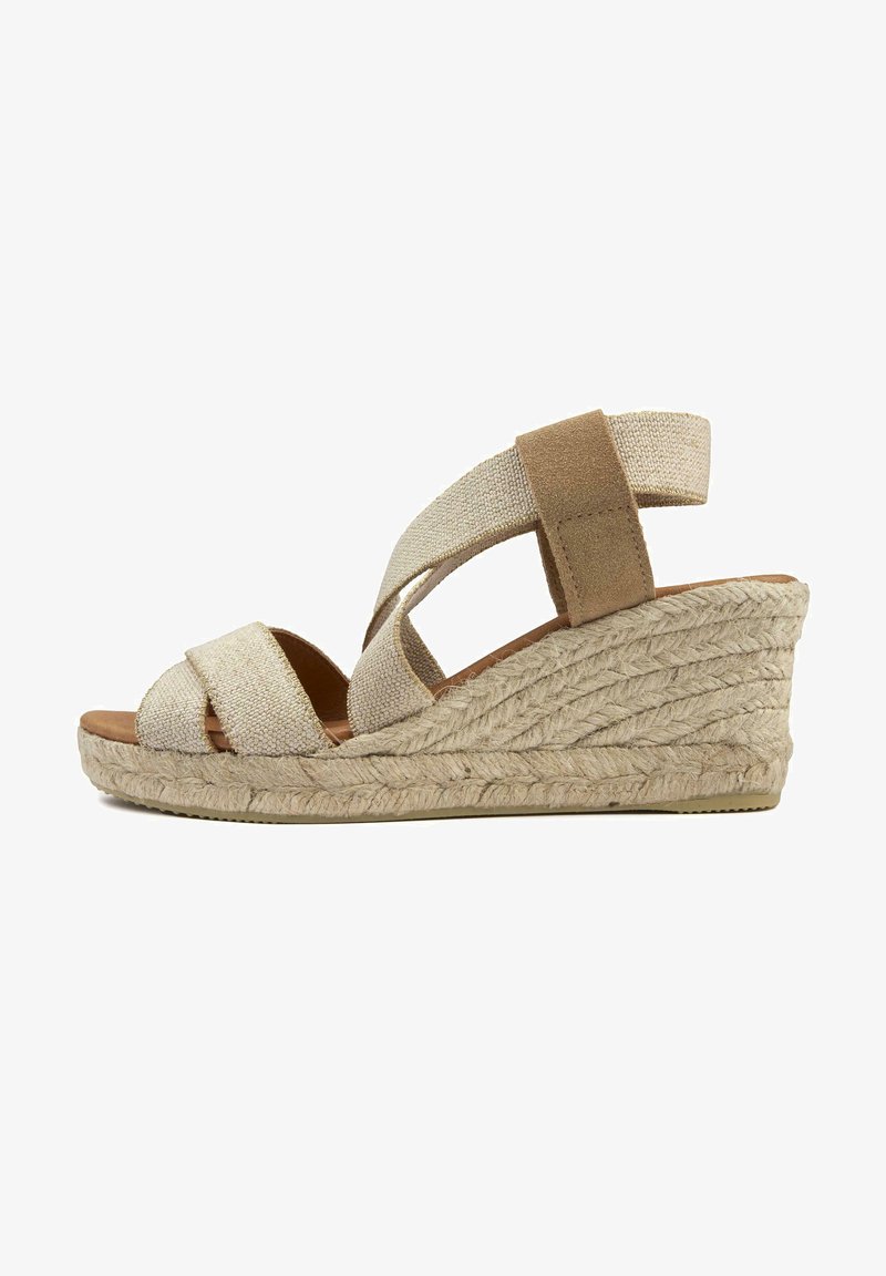 Wedge sandal with beige textile upper, overlapping straps, and a jute-wrapped platform. Features a soft footbed and rubber outsole.
