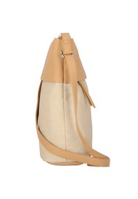 Beige tygaxelväska med en texturerad yta, en tan läderövre del och en lång justerbar rem. Har en simpel, rundad design.