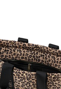 Tasje van leopardprint met opvulling, zwarte handvatten, gouden studs en een zichtbare ritszak met een merk-rits trekker.