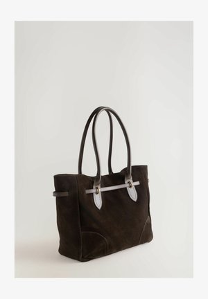 Pruunist nahast kandekotist, millel on kaks pikka nahkrist, hõbedatooni riistvara ja sinine aksentrihm. Rektaangulise kujuga, ümarate nurkadega.