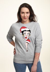 Sudadera gris con un gráfico de Betty Boop en rojo y blanco, acentuada con un gorro de Santa, y un corte relajado con puños de canalé.