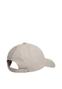 Gorra de béisbol beige ajustable mostrada desde atrás con cierre de hebilla metálica y correa de tela.