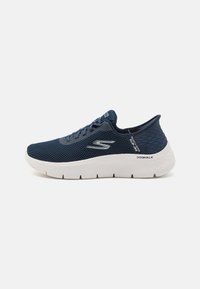 Navy blue mesh athletic shoe with a white outsole, textured heel, and logo accent; features a rounded toe and lace-up design for secure fit.