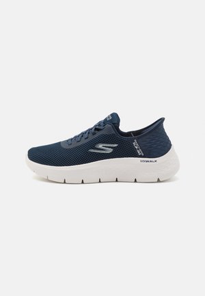 Navy blue mesh athletic shoe with a white outsole, textured heel, and logo accent; features a rounded toe and lace-up design for secure fit.
