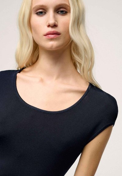 Top ribbed de culoare bleumarin, cu decolteu larg și mâneci scurte, având un material texturat și cusături fine pe margini.