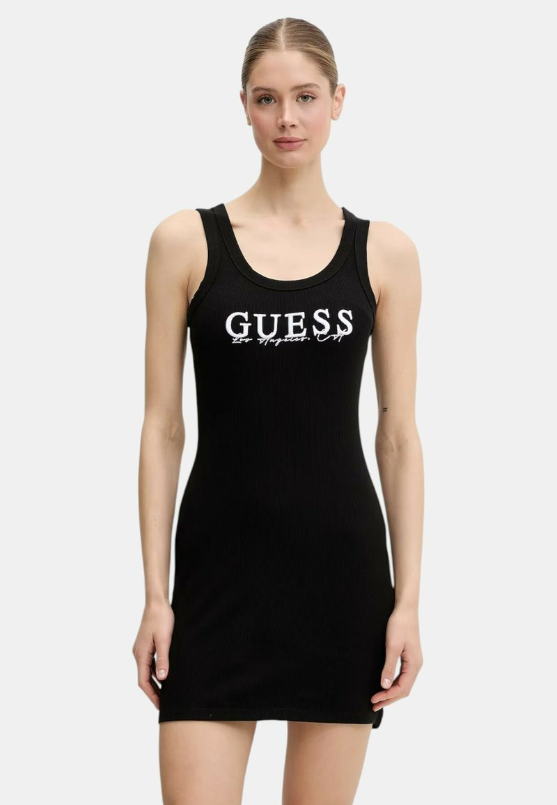 Abito a tubino nero a coste con silhouette aderente. Presenta il logo "GUESS" in bianco sulla parte superiore del petto. Design senza maniche con scollatura rotonda.