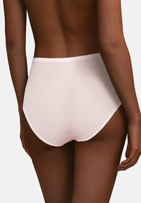 Slip a vita alta in rosa chiaro, realizzato in tessuto morbido con un design senza cuciture, caratterizzato da una cintura elastica e morbida e senza cuciture visibili.