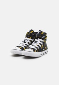 Zapatillas altas con una parte superior de tela negra que presenta patrones de rayos en amarillo y gris, cordones blancos y suelas de goma.