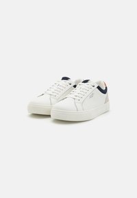 White sneakers featuring a smooth leather upper, navy accents on the collar, and a light tan heel tab. Classic lace-up design with textured soles.