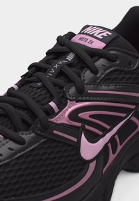 Μαύρο και ροζ αθλητικό παπούτσι Nike Moto 2K με διχτυωτό πάνω μέρος, συνθετικές επικάλυψεις και μαύρα κορδόνια.