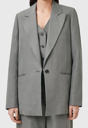 Grå linned blazer med spids lapel, enkelt knaplukning og to forlommer. Har en afslappet pasform og en tekstureret overflade.
