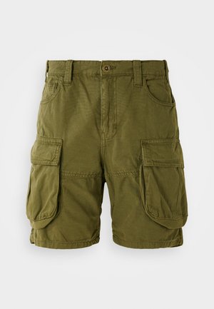 Shorts cargo vert olive en mélange de coton. Présente deux grandes poches latérales et une fermeture à bouton avec passants de ceinture. Texture lisse.