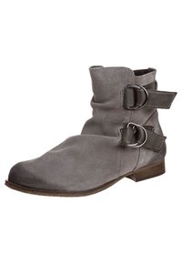 Bottine en daim gris avec deux brides décoratives à boucle, talon bas empilé et texture douce. Caractéristiques d'un bout arrondi et d'un design souple.