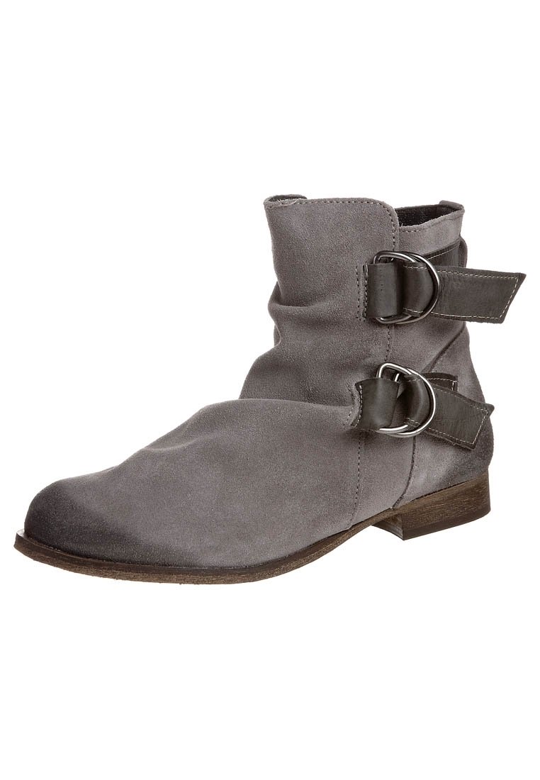 Bottine en daim gris avec deux brides décoratives à boucle, talon bas empilé et texture douce. Caractéristiques d'un bout arrondi et d'un design souple.