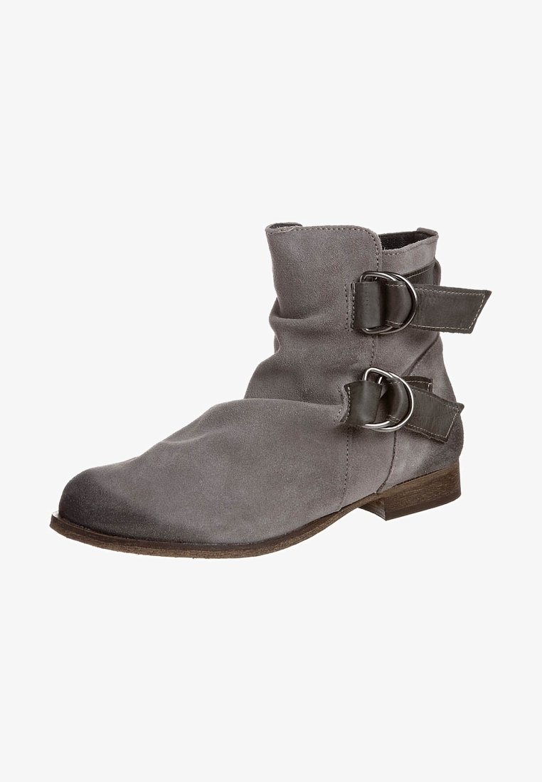 Bottine en daim gris avec deux brides décoratives à boucle, talon bas empilé et texture douce. Caractéristiques d'un bout arrondi et d'un design souple.