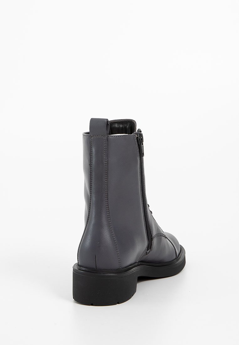 Dunkelgraue Leder-Stiefelette mit seitlichem Reißverschluss, Zuglasche und dicker schwarzer Sohle, von hinten auf einem weißen Hintergrund gezeigt.