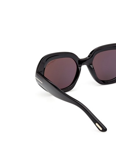 Occhiali da sole neri oversize con lenti scure. Finitura lucida, montatura angolare e un sottile accento in metallo sulle tempie. Design moderno.