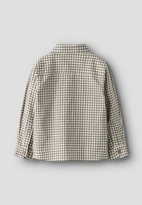 Hnědá a bílá kostkovaná košile na knoflíky, s dlouhými rukávy, špičatým límcem a bočními rozparky. Vyrobená z lehké bavlněné látky.