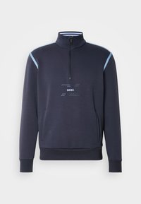 Felpa con zip della marina con colletto alto, spalle azzurre chiaro, tasca frontale e logo grafico "BOSS" sul petto. Tessuto in misto cotone.