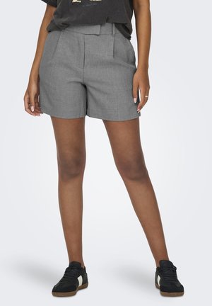 Γκρι κομμένα σορτς με υφή, με πλαϊνές πιέτες και μέση. Συνδυασμένα με μαύρα αθλητικά παπούτσια.