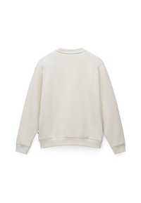 Sweatshirt color crema con una texture liscia, polsini e vita a coste. Presenta un collo tondo e nessun marchio visibile.