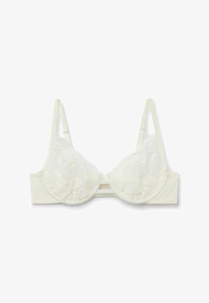Soutien-gorge crème en dentelle avec des bonnets moulés, des bretelles fines ajustables et un motif floral décoratif sur le tissu. Dispose d'une fermeture à agrafe.