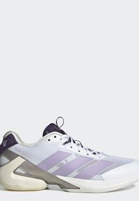 Chaussure de sport blanche et violet clair avec une tige en mesh, trois bandes violettes sur le côté et un design unique de soutien du talon angulaire.