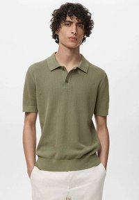 Polo shirt in verde oliva a maglia con maniche corte, colletto e motivo testurizzato. Include una placca con tre bottoni e orlo a coste.