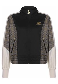 Black zip-up jacket with beige and brown plaid side panels, white long sleeves, and gold New Balance logos on chest and zipper pull.