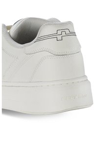 Sneaker bianca con tomaia in pelle testurizzata, collo imbottito e una suola in gomma prominente con il logo "PEGADOR" in rilievo.